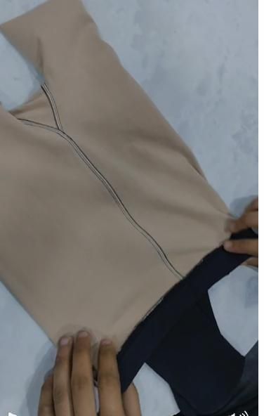 Beige fabric with black stitching on a white background